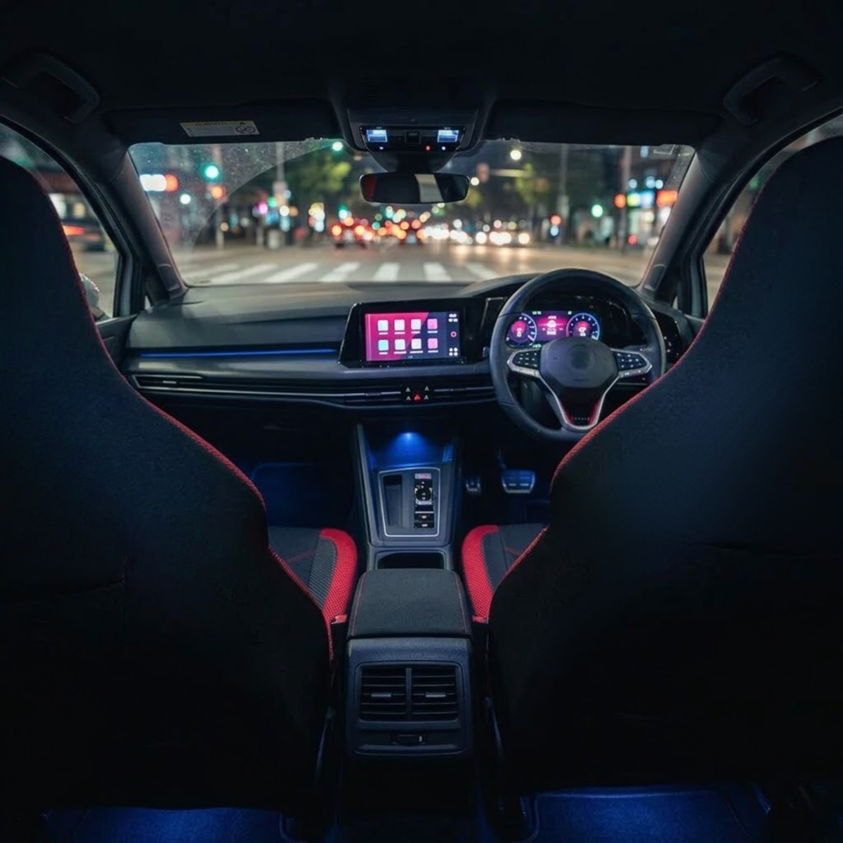 Rear view of black and red Sport Mesh Car Seat Covers fitted to front seats in a car interior at night