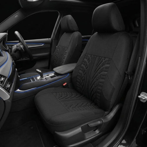 Black car seat covers installed on the front seats of a vehicle interior, featuring textured geometric patterns on the seat backs and seats, shown with blue ambient lighting accents.
