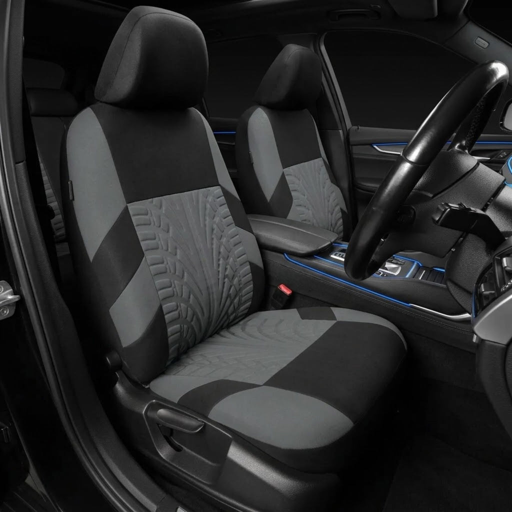 A pair of gray and black car seat covers installed on the front seats of a vehicle interior, featuring quilted and textured panel designs.