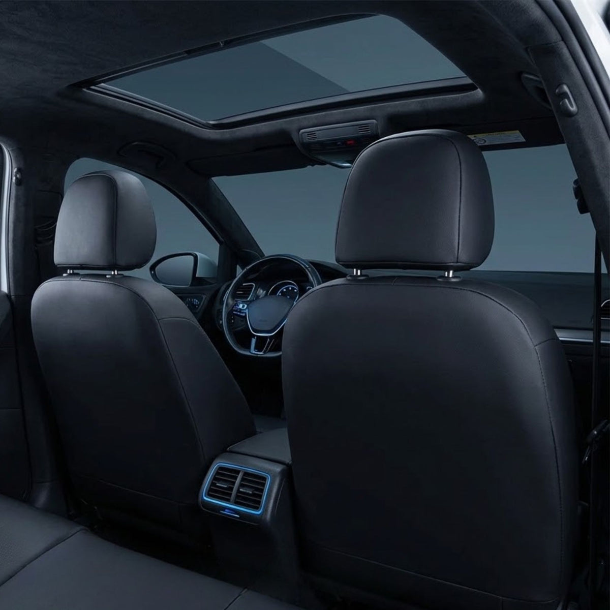 Black leather car seat covers installed on the front and rear seats of a vehicle interior, shown from the back seat viewing area with a sunroof.