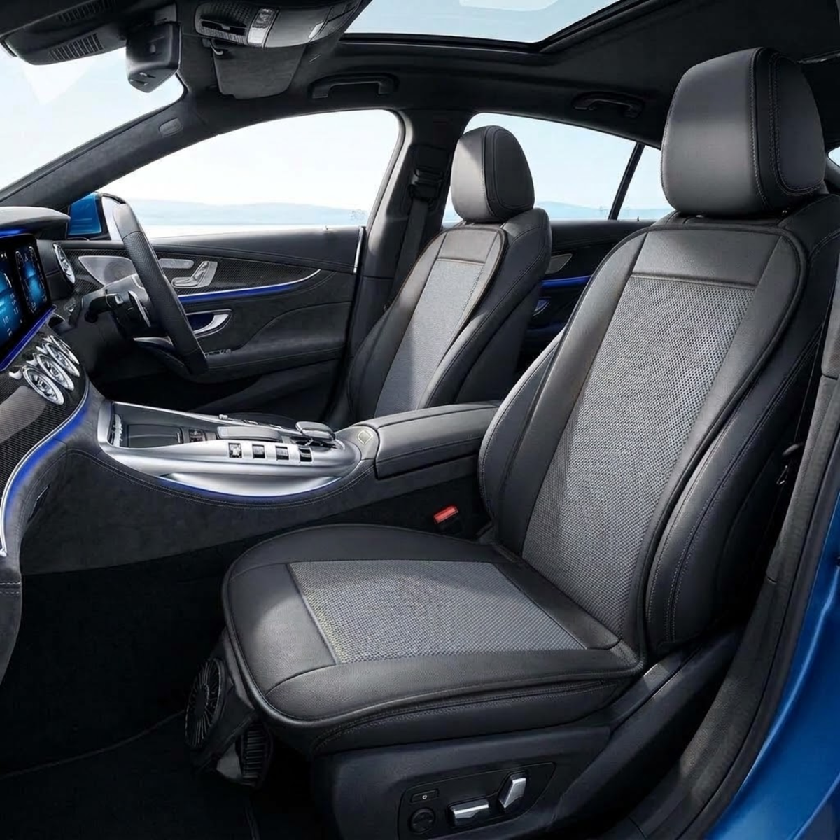 Black car seat covers installed on the front seats of a luxury vehicle, featuring a textured pattern on the center panels and smooth black leather edges, shown in a bright modern car interior.