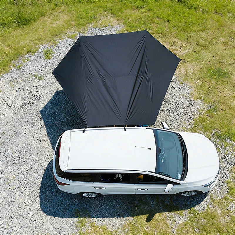 Aerial view of the black car side awning attached to a white SUV, demonstrating the aerodynamic bat-wing shape and expansive coverage area.