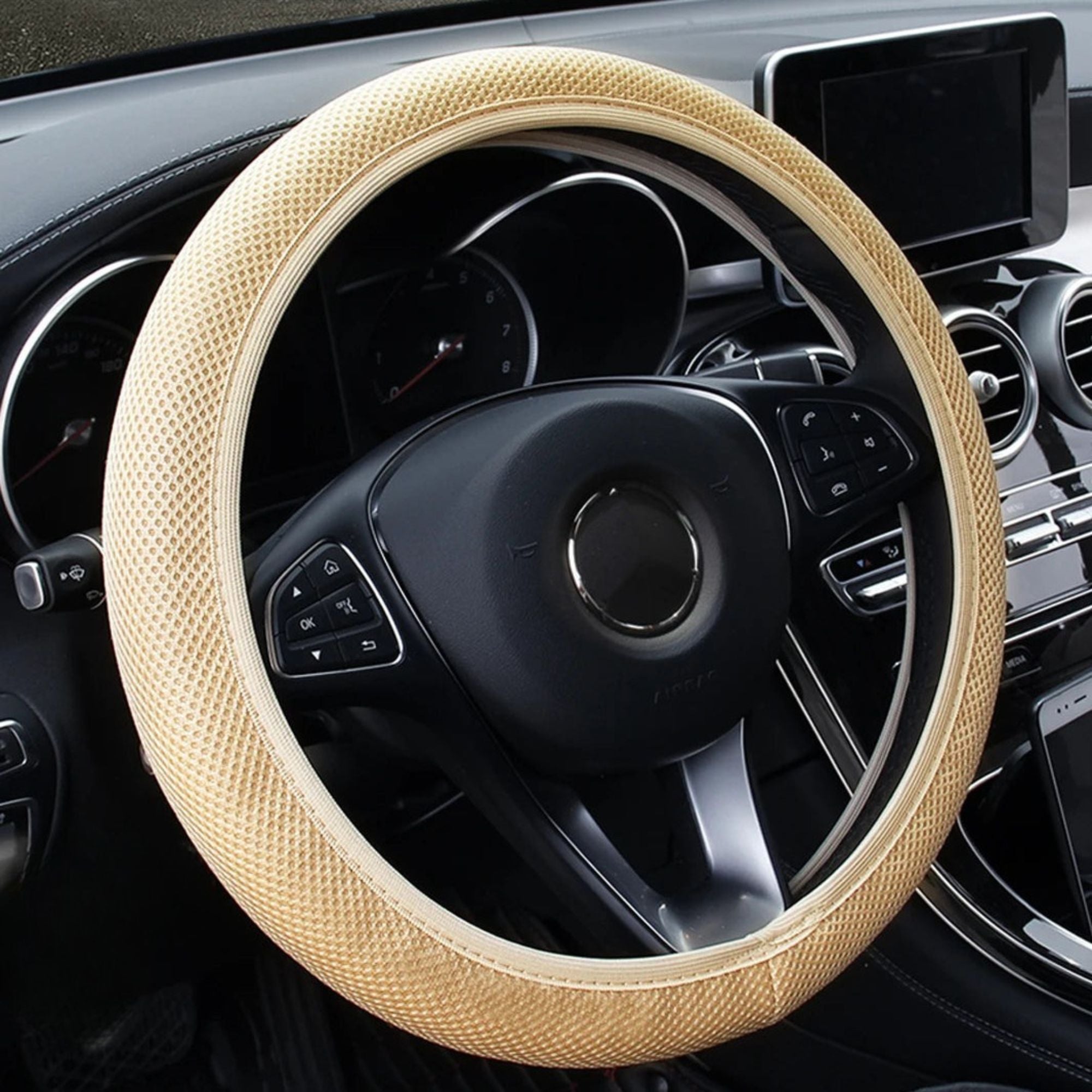 Beige mesh steering wheel cover fitted on a car steering wheel, breathable knitted colourway