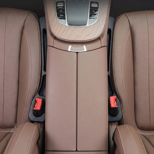 Top-down view of two black car seat gap fillers cleanly installed between the front leather seats and the center console of a vehicle.