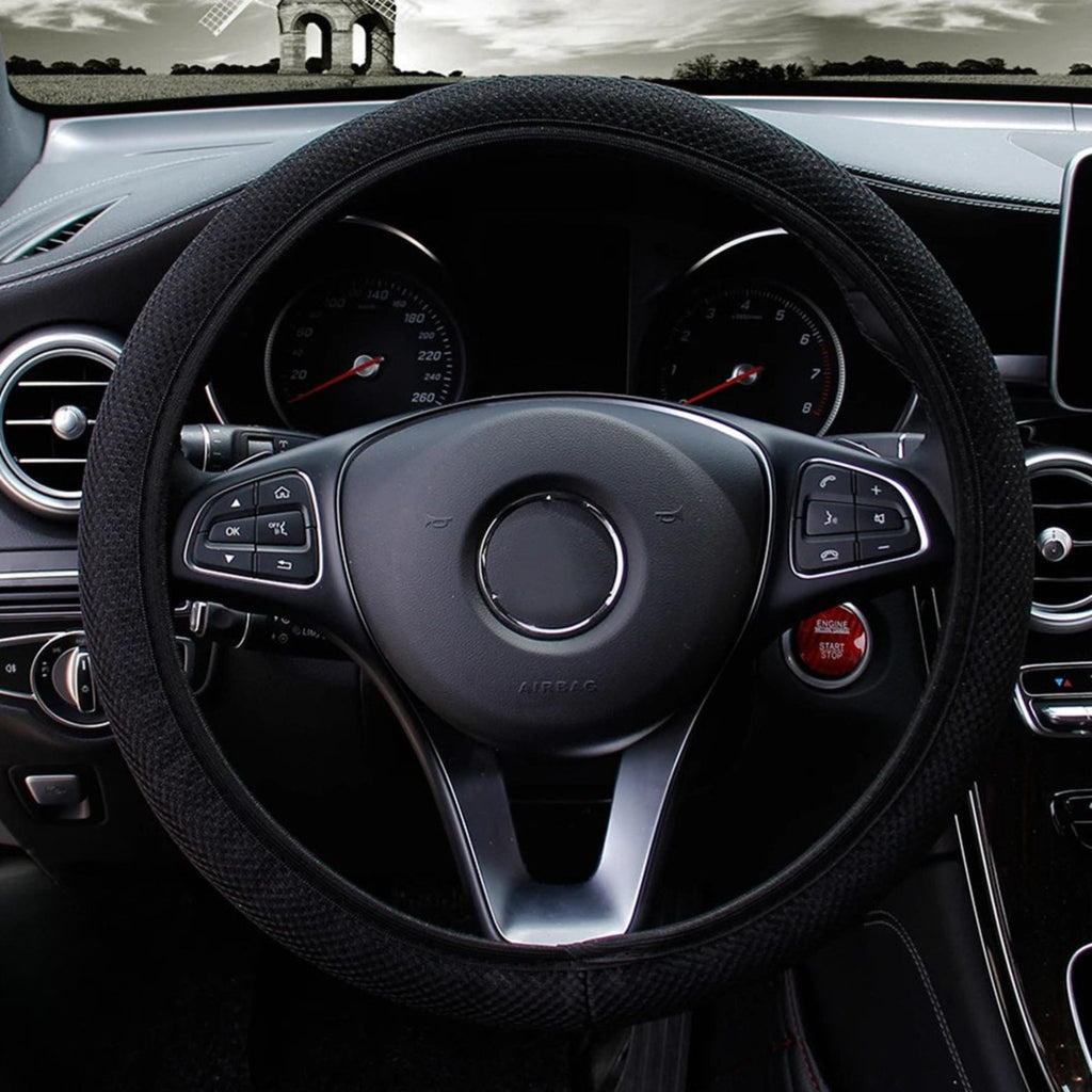 Black mesh steering wheel cover installed on a car steering wheel showing breathable double-layer grip