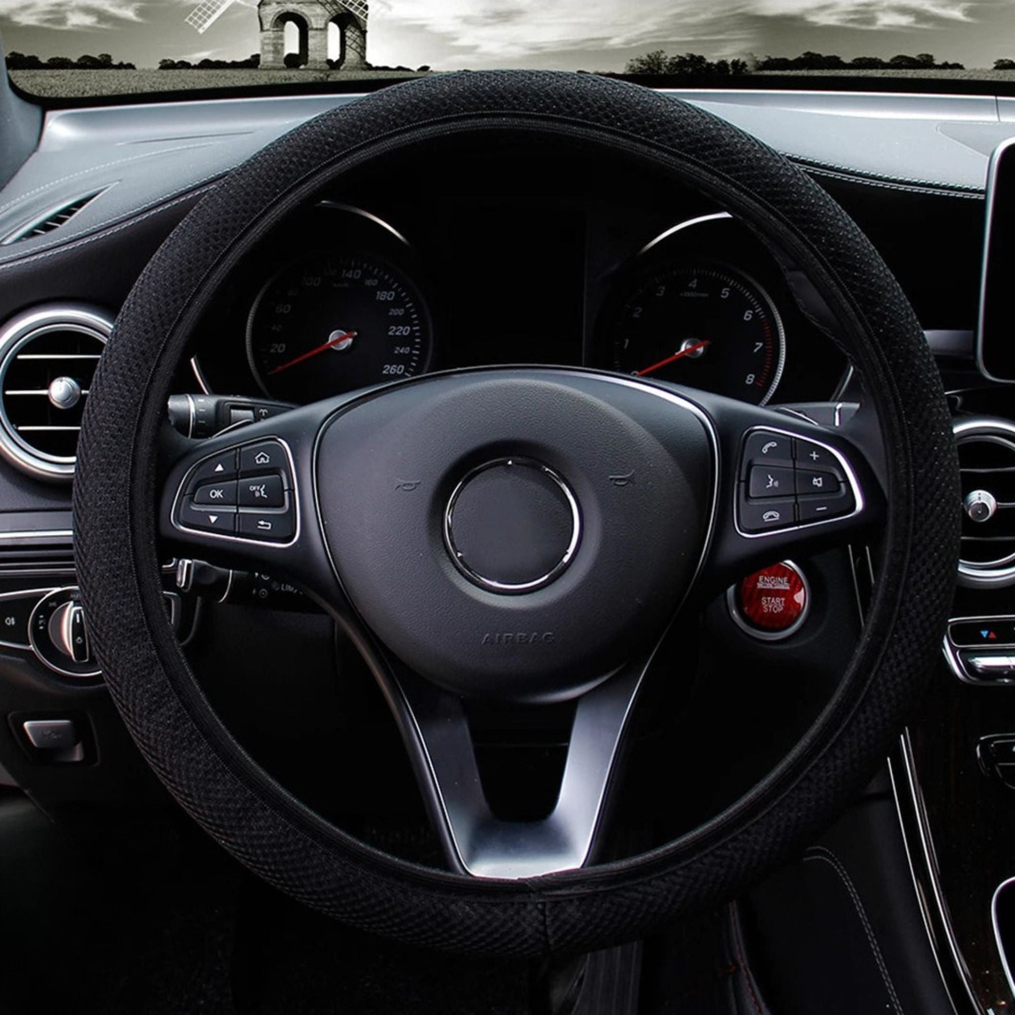Black mesh steering wheel cover installed on a car steering wheel showing breathable double-layer grip