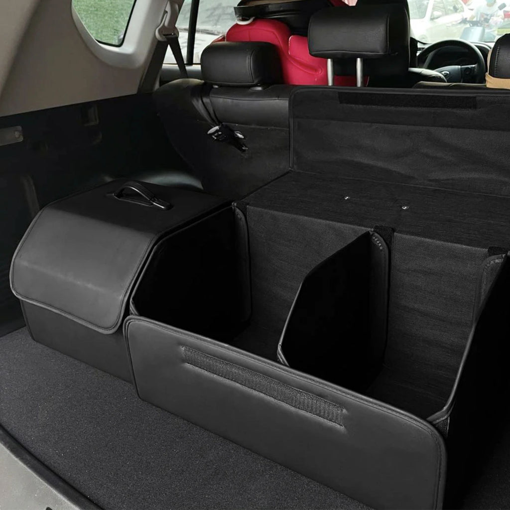 Close up view of an open black leather car boot organiser revealing deep storage compartments and adjustable velcro dividers.