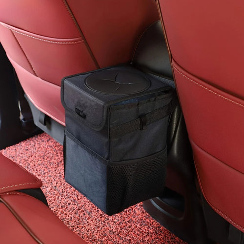 Black car rubbish bin installed on the back of a red vehicle passenger seat.