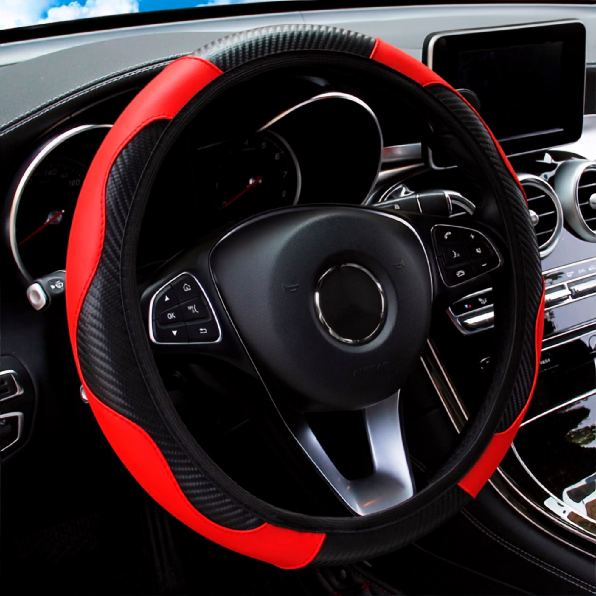 Red and black PU leather steering wheel cover with carbon fibre panel fitted to a car steering wheel