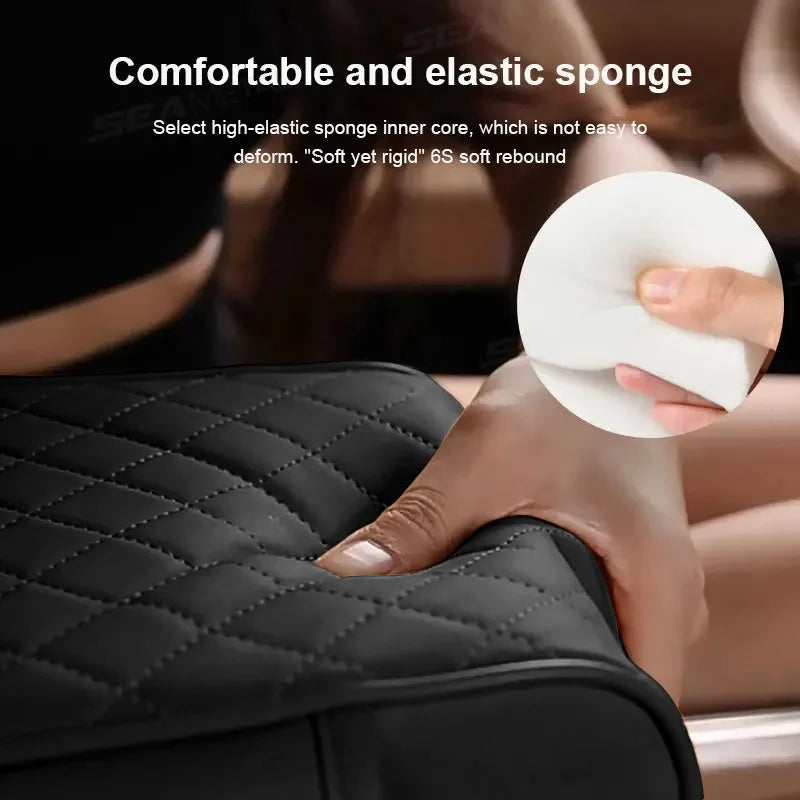 Hand pressing into the quilted surface of the centre console armrest cushion, demonstrating the internal elastic sponge material.
