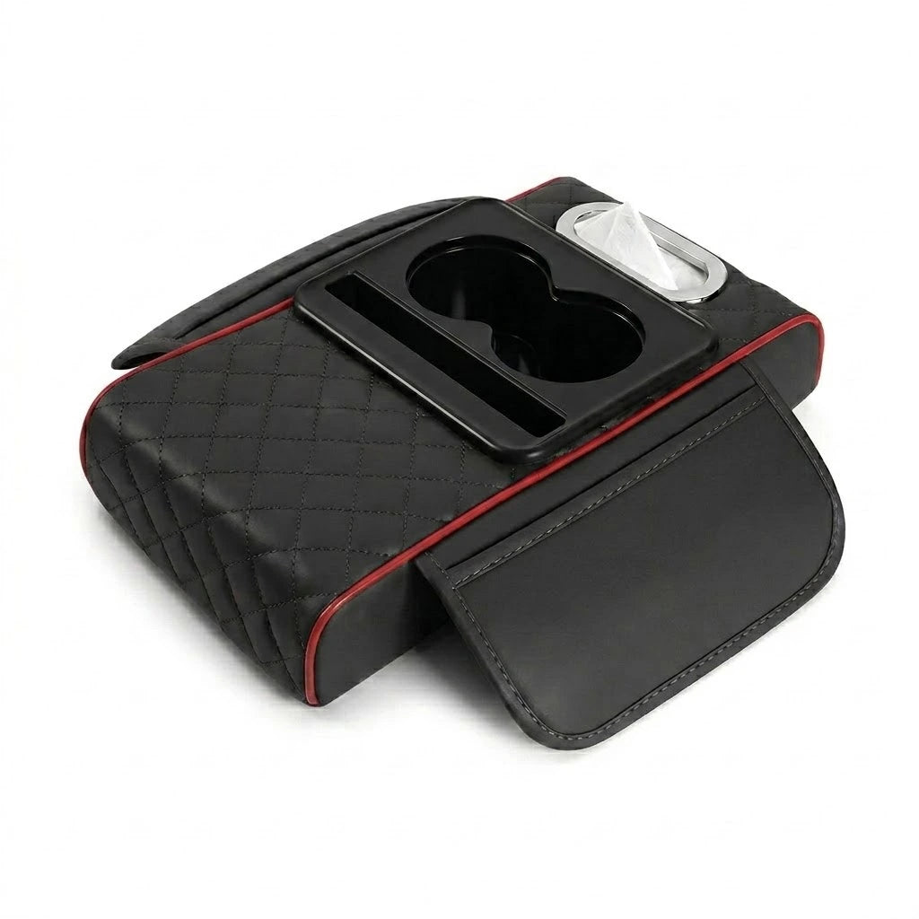 Black centre console armrest cushion with red stitching trim, displaying the dual cup holders and tissue dispenser slot.