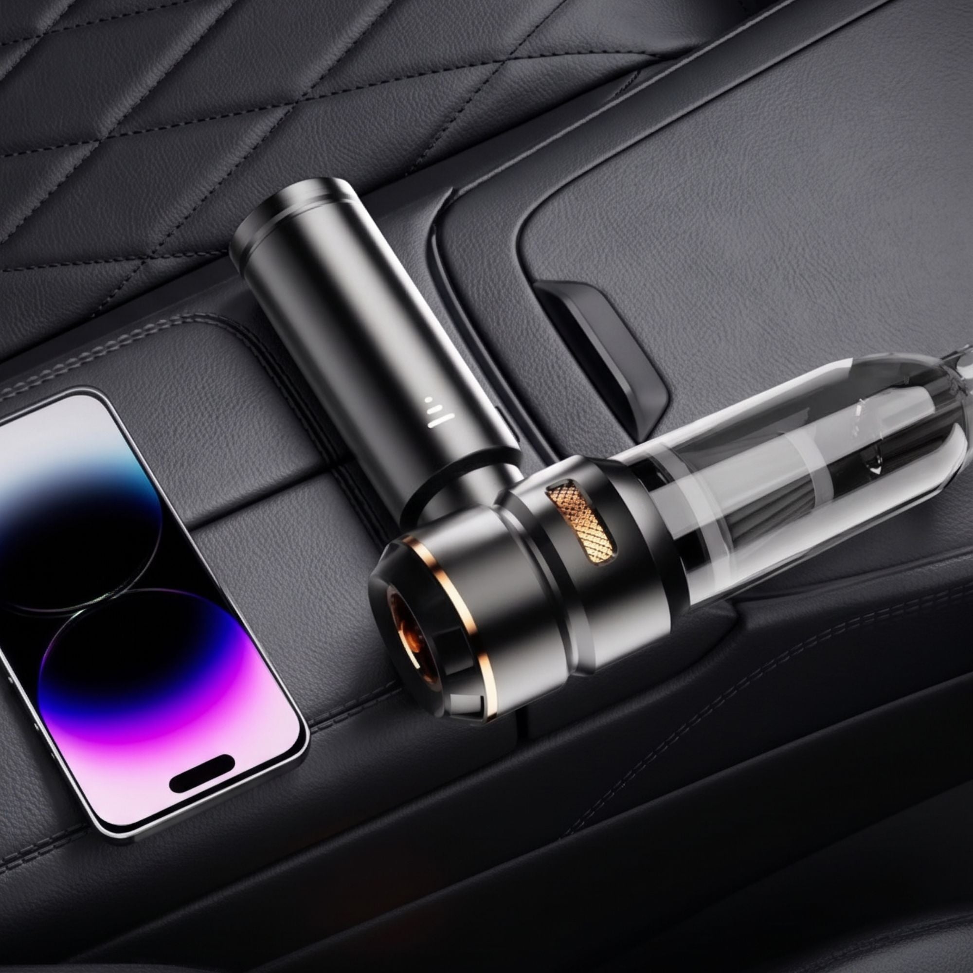Compact black cordless car vacuum cleaner lying flat next to a smartphone inside the matte-black centre console storage tray of a high-end vehicle.