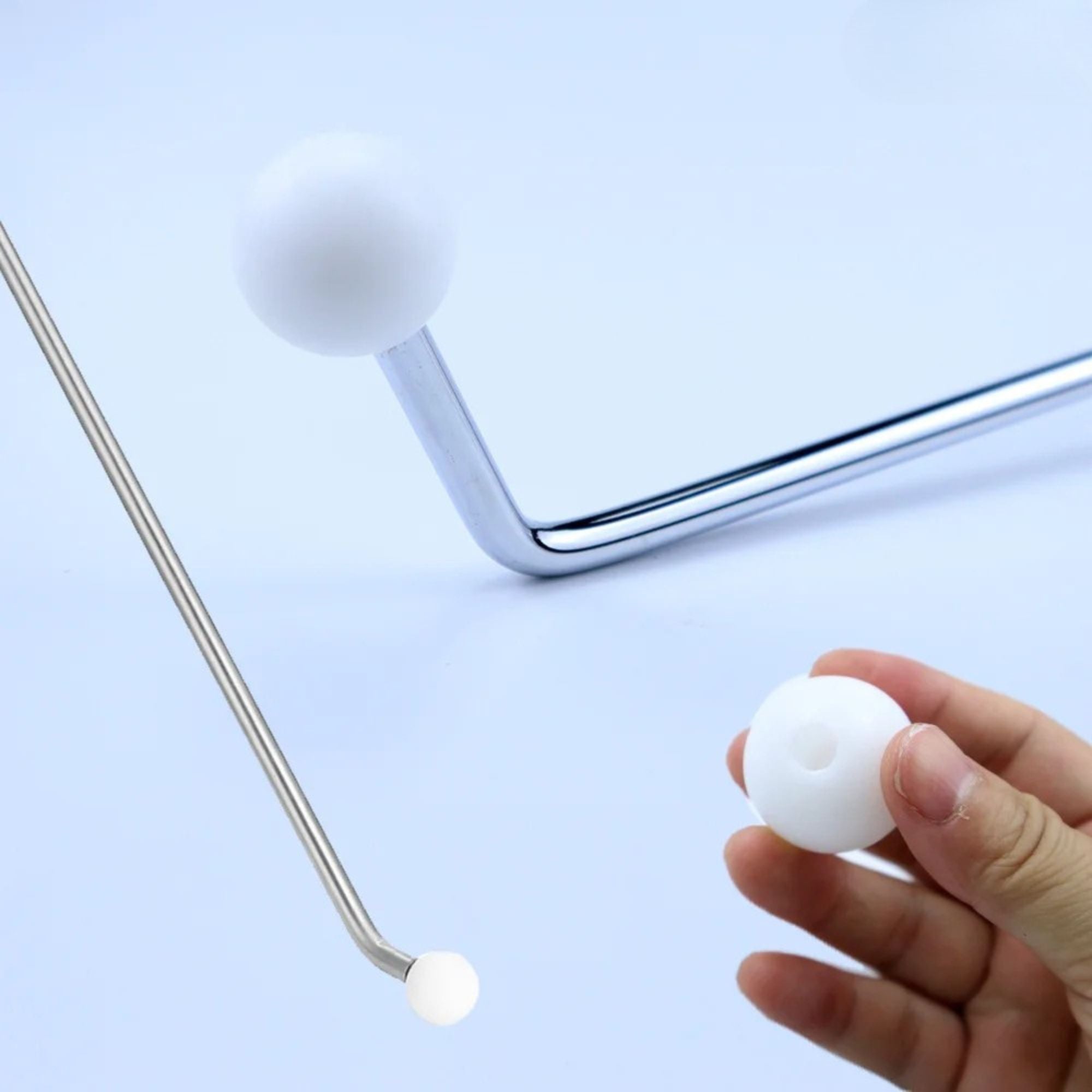 Close-up showing a white rounded composite tip being manually threaded onto the tip of the stainless steel paintless dent removal rod.