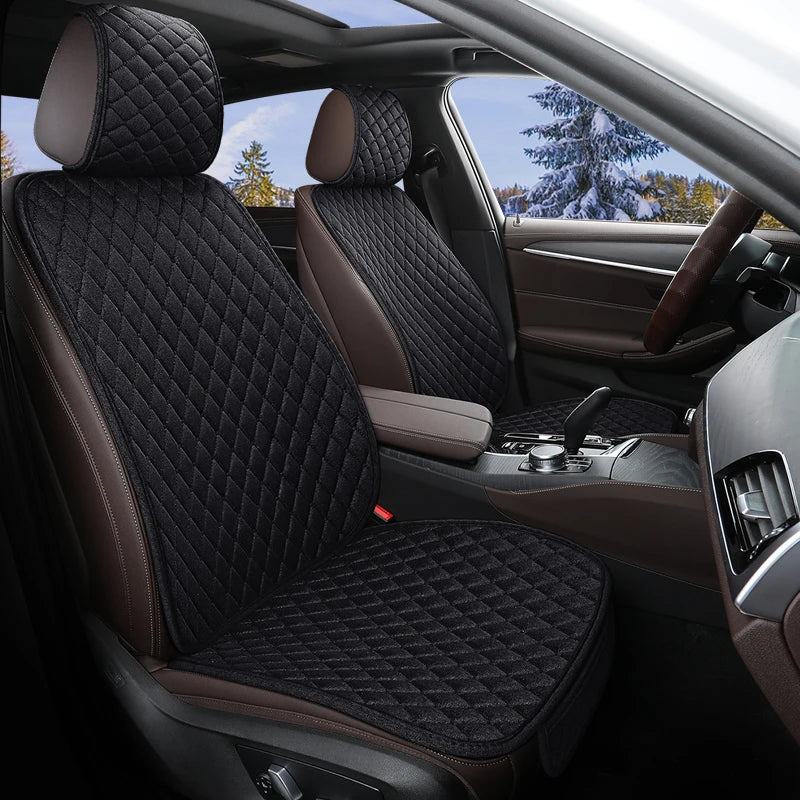 Black diamond-quilted linen car seat protectors installed on the front seats of a passenger vehicle interior.