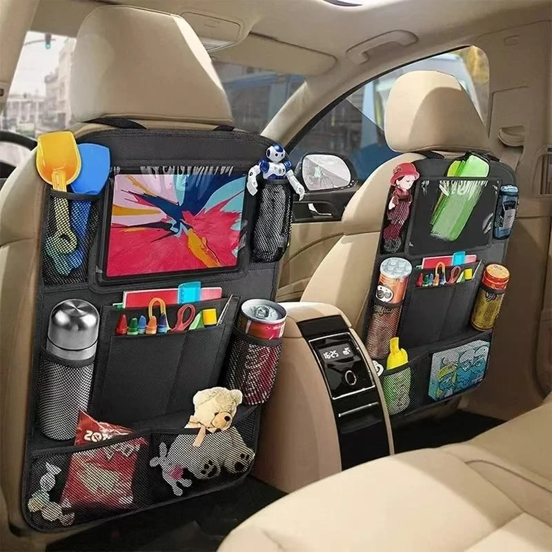 Two black multi-pocket car backseat organisers installed on the driver and passenger seats, holding various travel items within a vehicle interior.