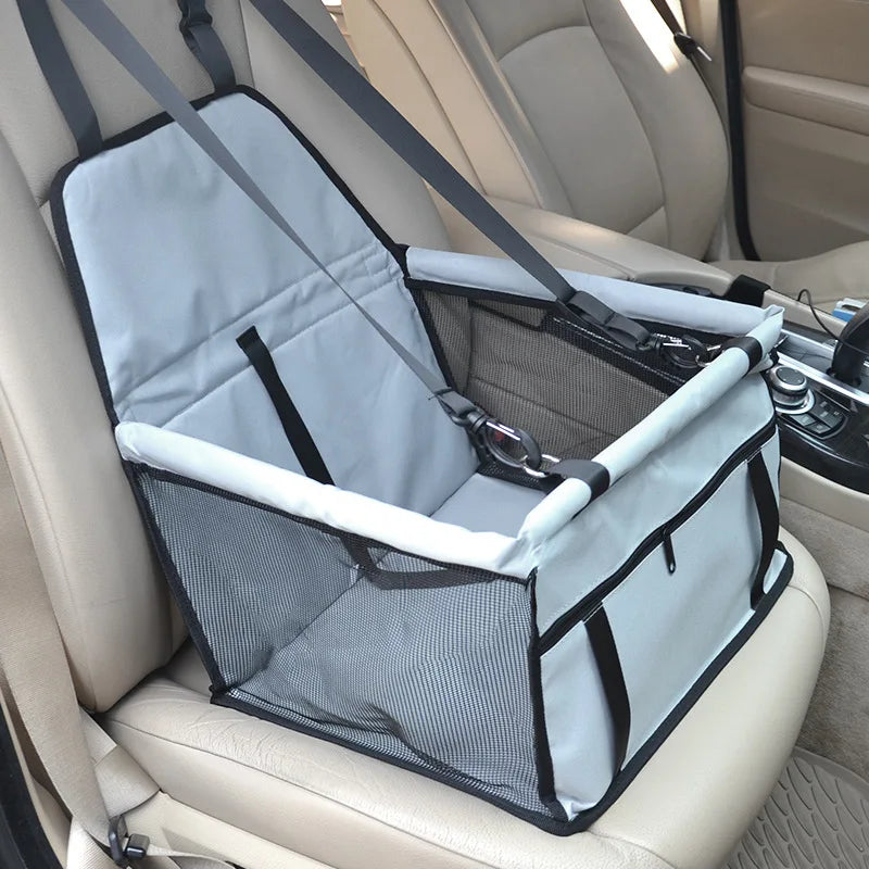 Grey folding pet car seat carrier installed empty on a car seat, detailing the internal structure and front zipper pocket.