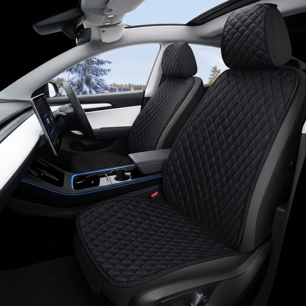 Black quilted car seat covers installed on the front seats of a modern vehicle interior, shown with the car door open and a snowy outdoor landscape visible through the window.