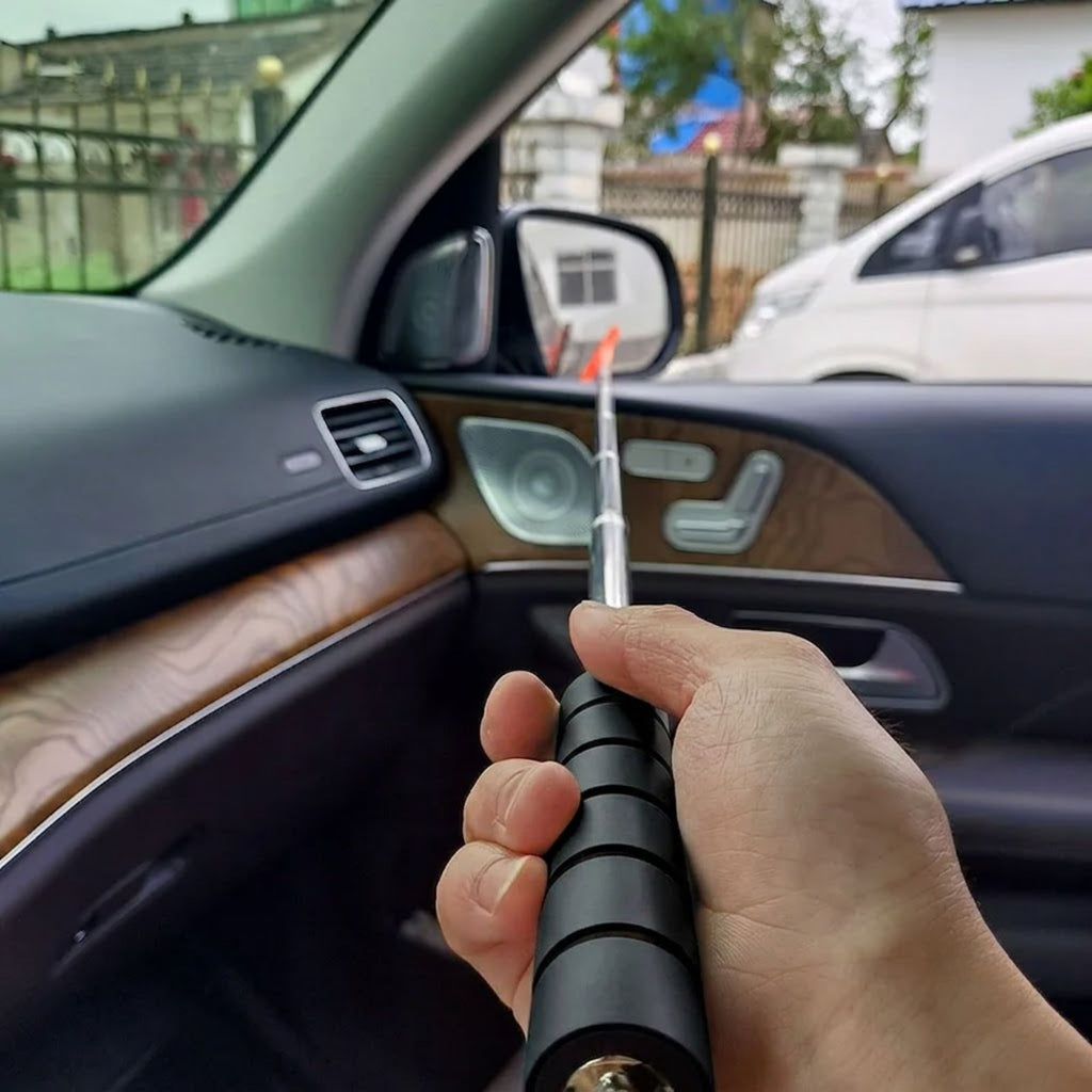 Hand holding the Telescopic Car Rearview Mirror Wiper extended inside a car, reaching toward the wing mirror