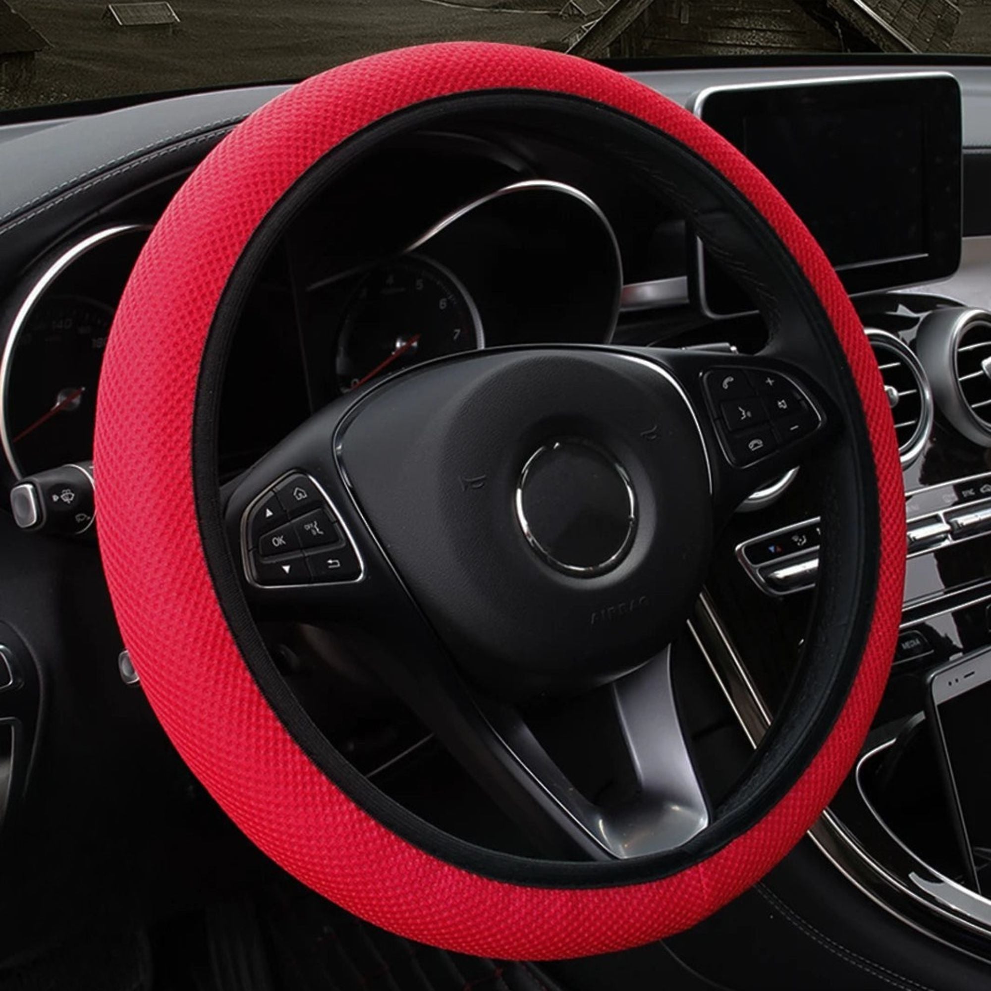 Red mesh steering wheel cover fitted on a car steering wheel, sporty accent colourway