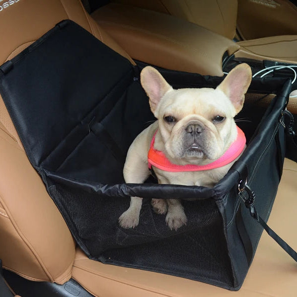 Black small dog car seat carrier installed on a vehicle passenger seat with a French Bulldog sitting inside.