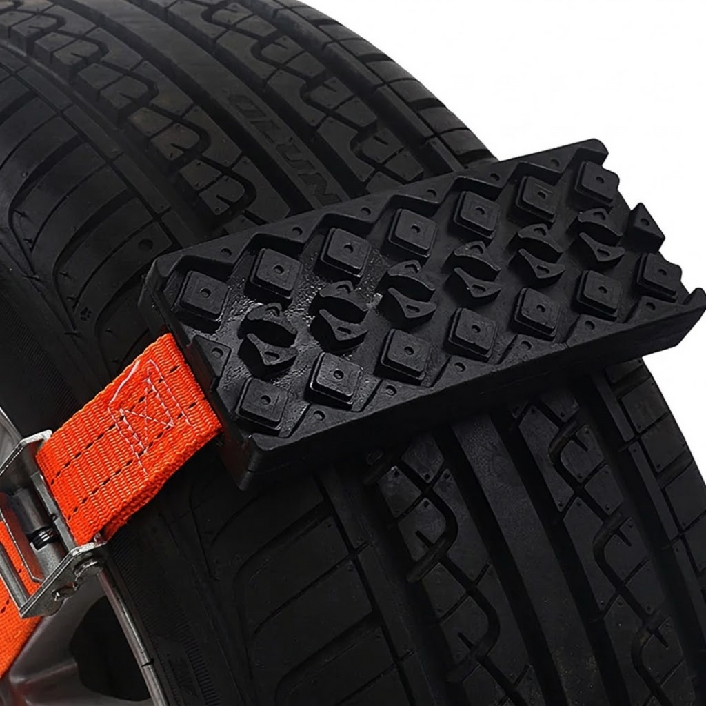 Close-up of a Strap-On Tyre Traction Cleat secured to a car tyre tread with an orange strap and metal buckle