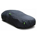 A black universal all-weather full car cover featuring green high-visibility reflective strips, installed on a vehicle against a white background.