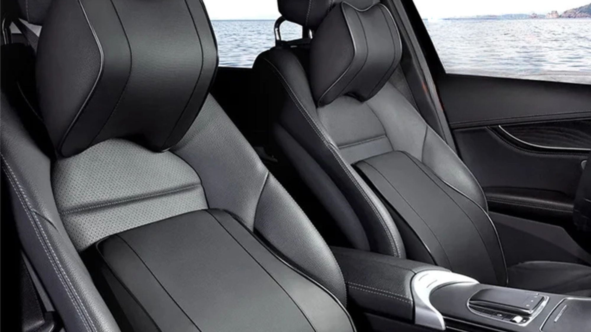 Black leather car seats with a view of water through the windows